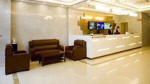 A reception area with a reception desk, two sofas, and a coffee table. - Greentree Inn Huanggang City Wuxue City Kanjiang Avenue (Huanggang)