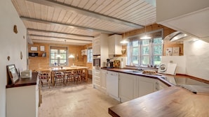 A spacious kitchen with wooden beams, white cabinets, and a large window providing natural light. - 3 bedroom gorgeous home in Højslev (Højslev)
