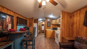 A wooden interior with a kitchen, dining area, and a living room. - Choctaw: Sleep 4, Tiny Cabin, Pets, Near Park/Lake (Broken Bow)