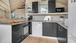 A modern kitchen with black and white cabinetry, a built-in dishwasher, and a microwave.