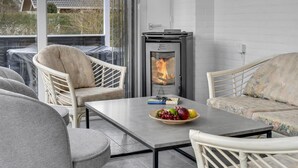 Ein Balkon mit Tisch, Stühlen, einer Feuerstelle und Blick auf ein Haus.