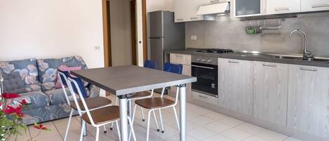 Een koelkast, een oven, een vaatwasser, eettafels