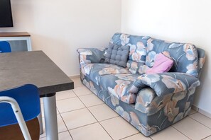 A room with a sofa, a table, and a chair. - S289 - Sirolo, delightful one bedroom apartment with porch (Sirolo)