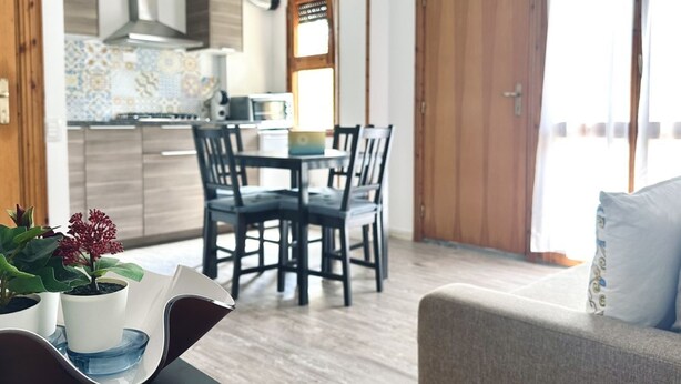 Une cuisine moderne avec un coin repas, des meubles en bois et une grande fenêtre.