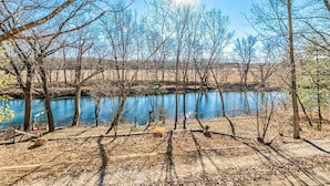 A natural landscape with a body of water, trees, and a fenced area. - Peaceful Niangua River Retreat (Buffalo)
