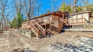 A rustic cabin with a wooden staircase leading to a deck, surrounded by trees. - Peaceful Niangua River Retreat (Buffalo)