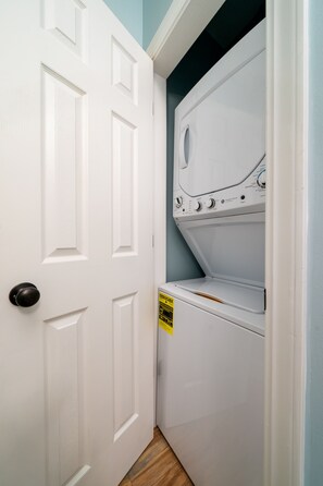 Une buanderie avec une porte blanche et un lave-linge.