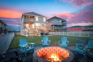 A two-story house with a fire pit and outdoor seating.