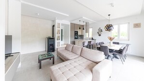 A modern living room with a beige sectional sofa, a glass coffee table, and a fireplace. - Lovely home in Primorski Dolac (Primorski Dolac)