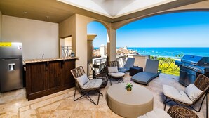 A patio with outdoor seating, a grill, and a view of the ocean. - Oceanview Penthouse in Heart of Tamarindo - Perfect Location & Comfort (Tamarindo)