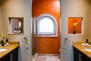 A bathroom with two sinks, a large arched window, and a mirror above each sink. - Oceanview Penthouse in Heart of Tamarindo - Perfect Location & Comfort (Tamarindo)