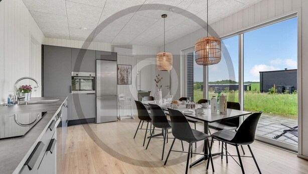 A modern kitchen with a dining area, large windows, and a view of the outdoors. - 4 bedroom beautiful home in Løgstrup (Løgstrup)