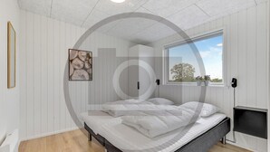 A bedroom with a bed, a window with a view, a radiator, and a framed picture on the wall. - 4 bedroom beautiful home in Løgstrup (Løgstrup)