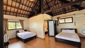Habitación con dos camas, ventilador de techo y ventana con cortinas.