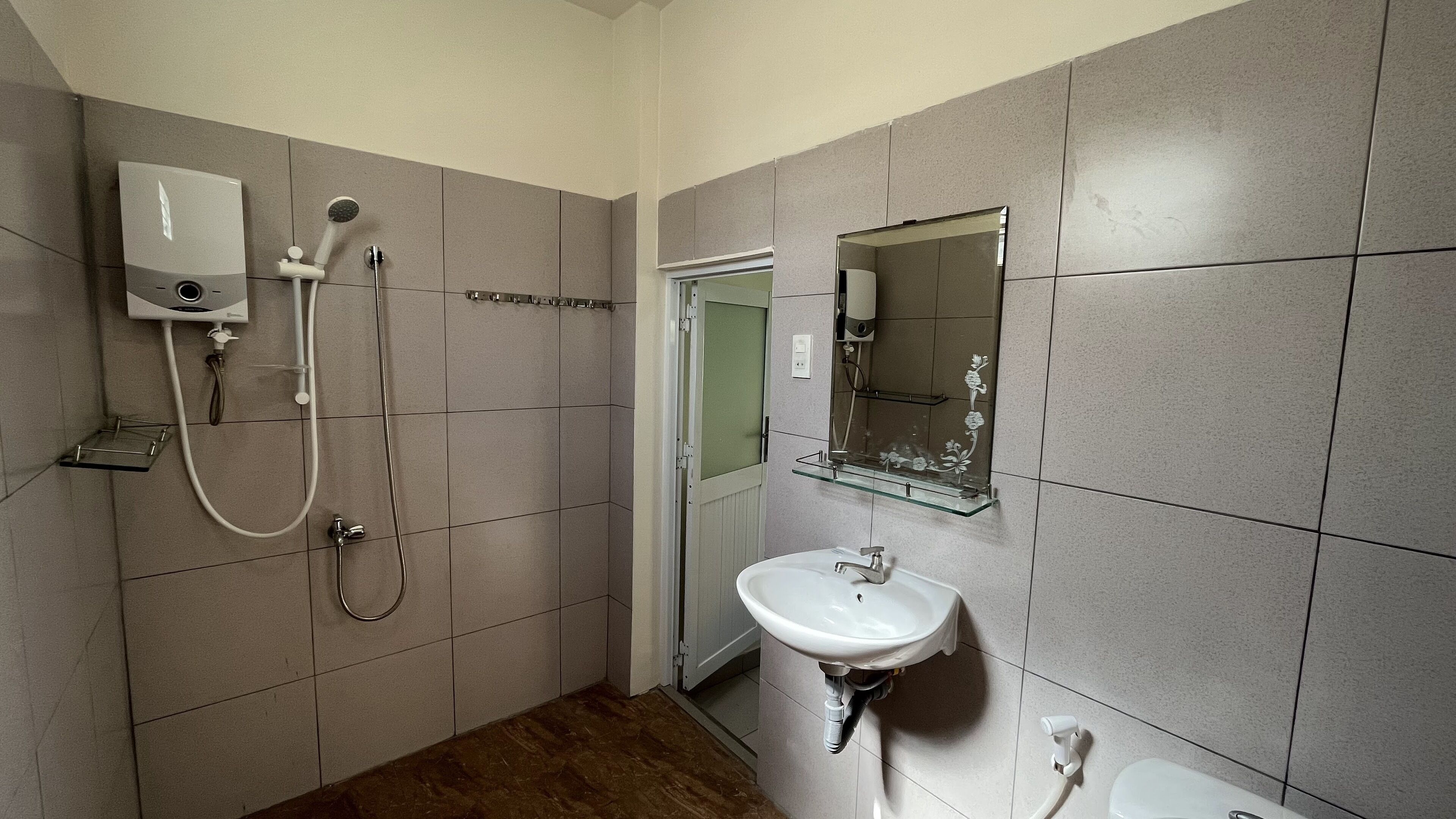 Ein Badezimmer mit Dusche, Waschbecken und Toilette.