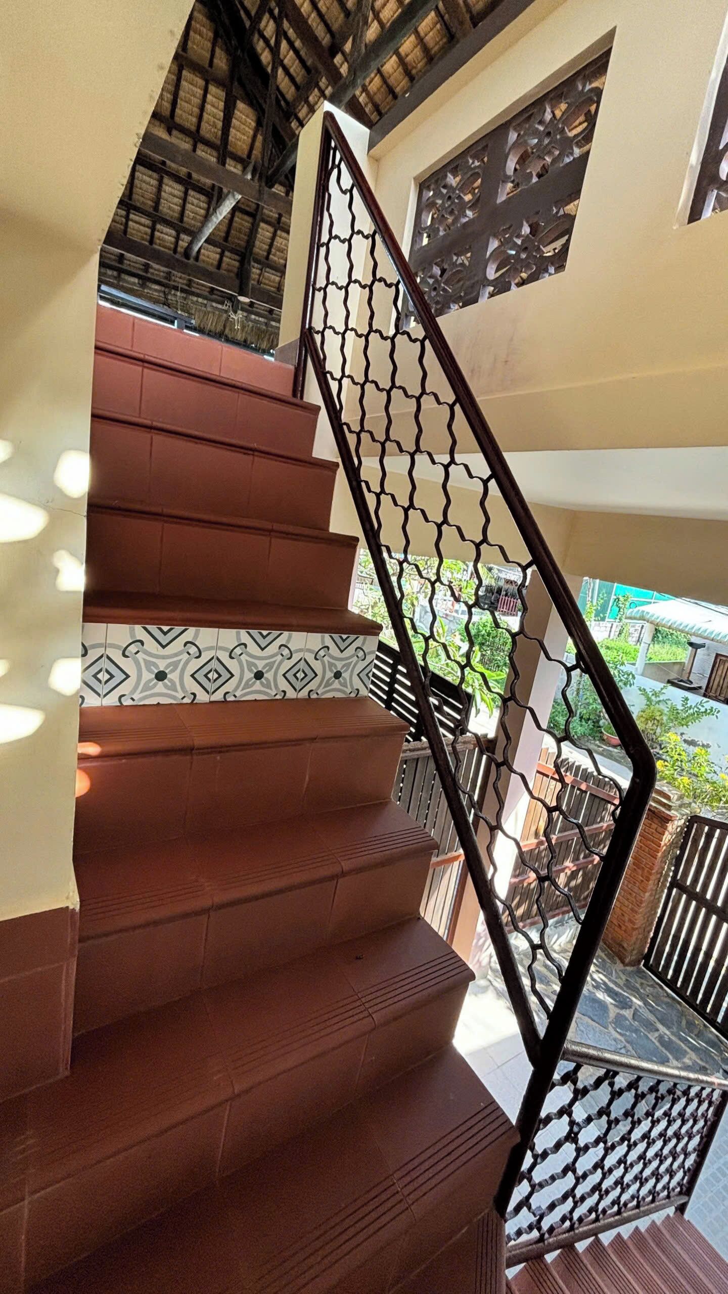 A staircase with a patterned handrail and a view of the outside.