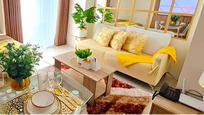 A modern living room with a sofa, coffee table, and plants. There is a dining area with a table set for two. - Inspiria Condo Units beside Abreeza Mall Davao (Davao)