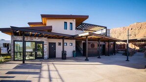 A modern building with a covered entrance, large windows, and a stone facade. - Moab Sage Creek Vista Views (Moab)