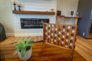 Un juego de mesa de madera sobre una mesa, con una planta en maceta a un lado.