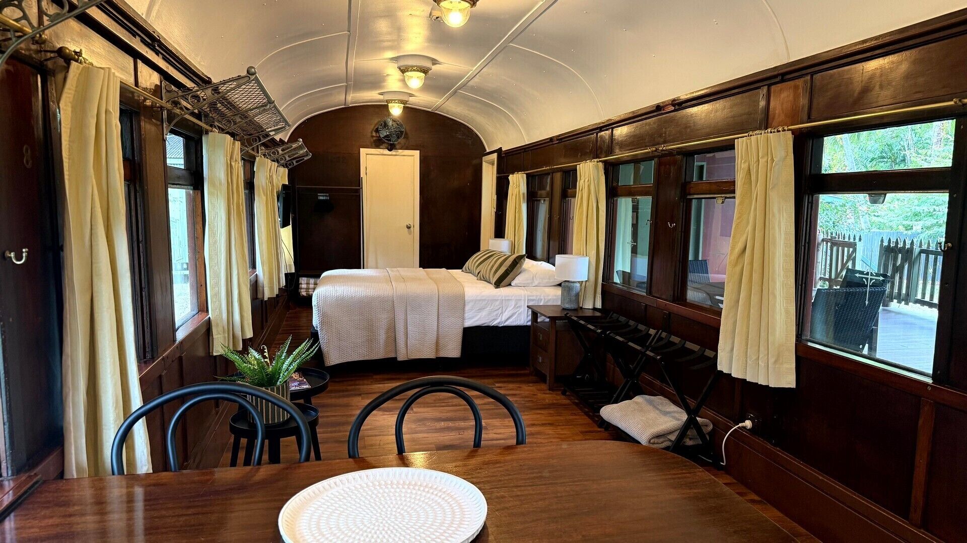 Un compartiment de train confortable, équipé d’un lit, d’une table, de chaises et d’un espace repas.