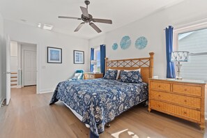 A bedroom with a bed, a wooden dresser, a ceiling fan, and a window with curtains. - "A Perfect Landing" is a 6 Bedroom / 6.5 Bath Home w/ Private Pool & Elevator. (Holden Beach)