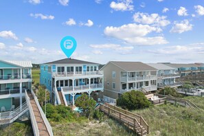 Un quartier résidentiel situé sur la côte, avec des maisons à plusieurs étages dotées de balcons et d’une piscine.