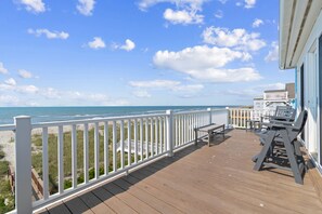 A wooden deck with a white railing overlooking a beach. - "A Perfect Landing" is a 6 Bedroom / 6.5 Bath Home w/ Private Pool & Elevator. (Holden Beach)