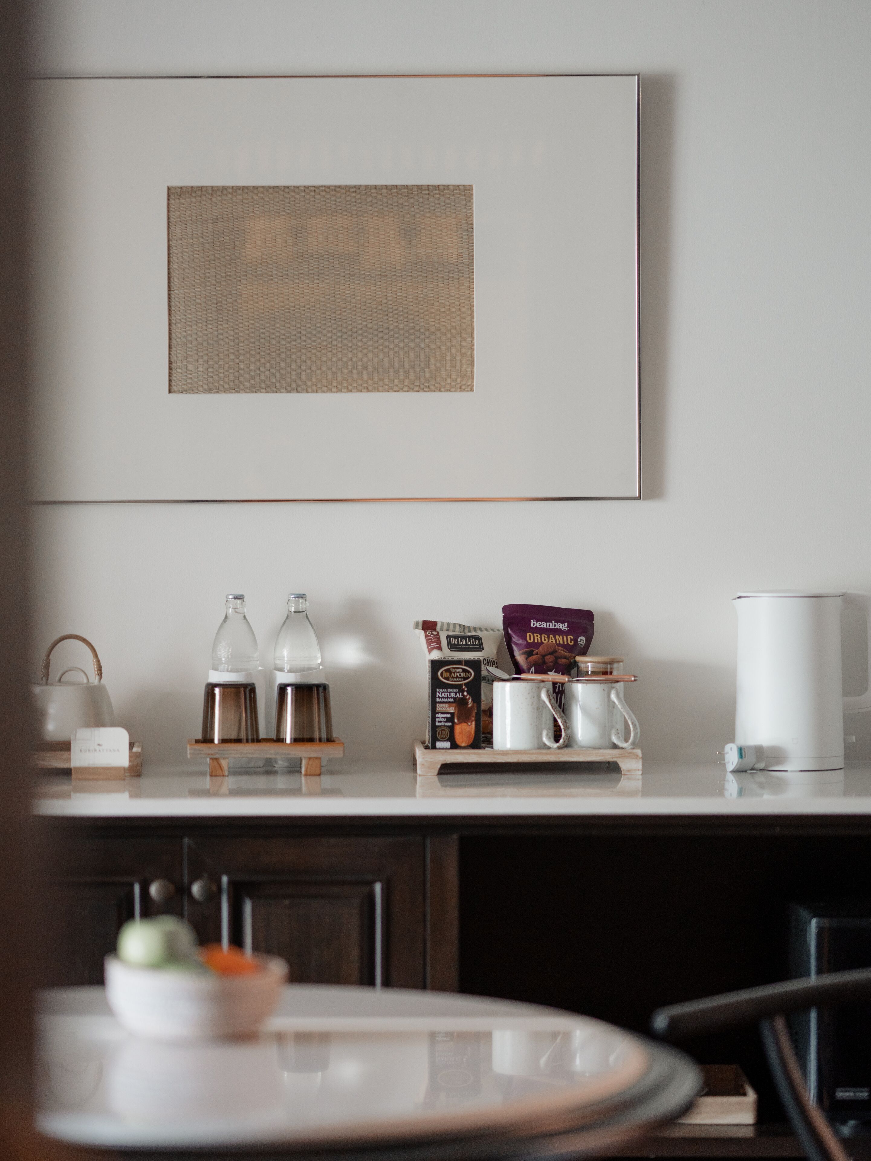 A kitchen with a coffee maker, a kettle, a coffee pod dispenser, and a coffee mug on the counter.