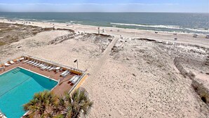A beach resort with a swimming pool, sun loungers, and a view of the ocean. - 👣 Come get your toes in the sand ~~~ and a cold drink in your hand! 🍹 (Gulf Shores)
