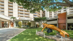 A hotel entrance with a large sculpture, a sign reading 'Kaanapali Shores,' and a multi-story building in the background.