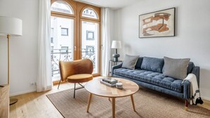 Un salon comprenant un canapé, un fauteuil, une table basse et une lampe.