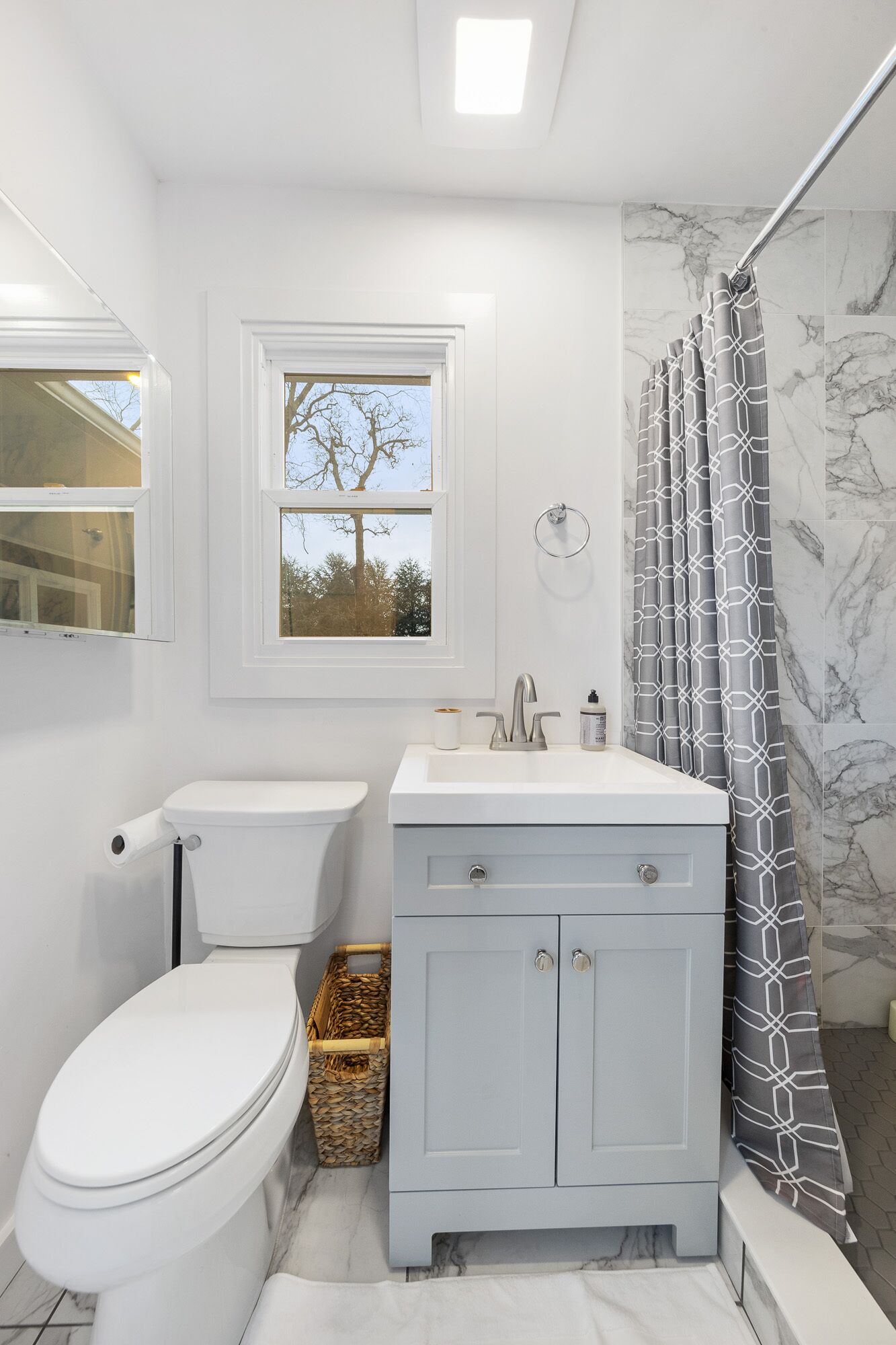A bathroom with a toilet, sink, and shower.