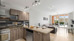 A modern kitchen with granite countertops, stainless steel appliances, and wooden cabinetry.