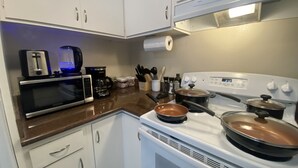 A kitchen with white cabinets, a microwave, a stove, and a toaster. - Cozy 1K & 1Q / 1b, 5 minutes walk to downtown (Lafayette)