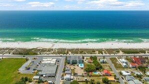 An aerial view of a coastal area with a beach, parking lots, and buildings. - LAGUNA DUNES! AMAZING VIEWS! GROUND FLOOR! (Panama City Beach)