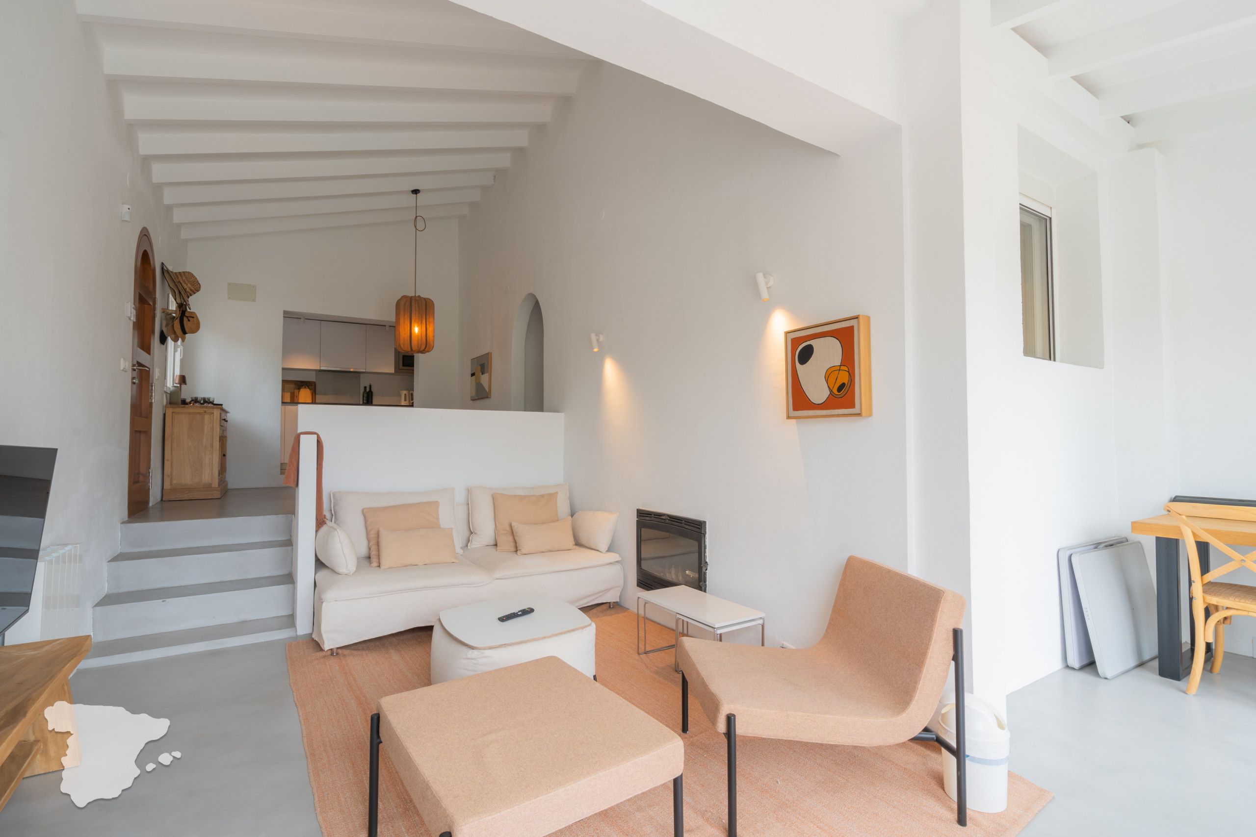 Ein modernes Wohnzimmer mit einer Couch, zwei Sesseln, einem Couchtisch und einem Kamin.