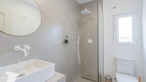 Ein modernes Badezimmer mit einer weißen Badewanne, einer Duschkabine und einer Toilette.