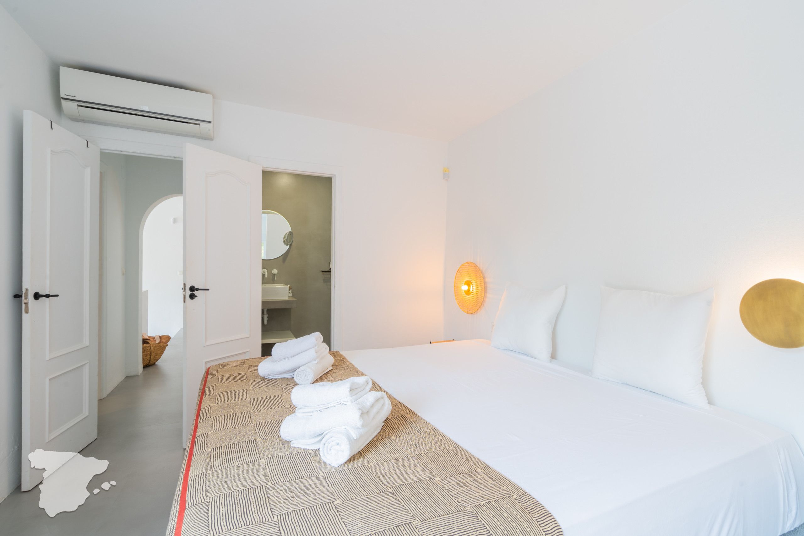 Una habitación de hotel con cama, baño y aire acondicionado.