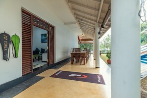 Ein Hotelkorridor mit Holzboden, einer Rezeption und einem Essbereich mit Stühlen und Tischen.