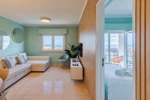 Relax in this stylish living room with a sofa, side table, and balcony offering a sea view.