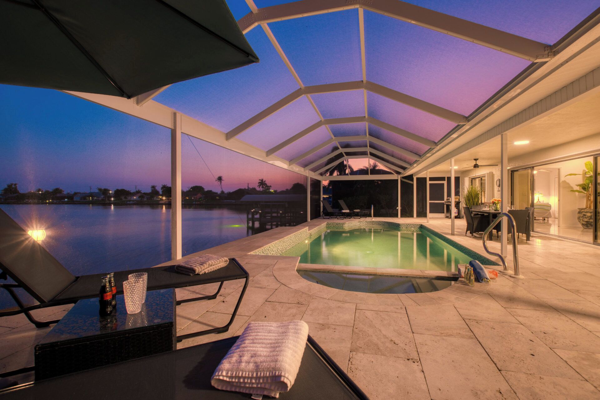 Une piscine extérieure avec des chaises longues et un patio couvert.