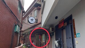 A narrow alleyway with a brick building on the left and a white building on the right. A sign with a coffee cup and Chinese characters is visible. - Jiufen Cafe Sleep B&B No.1 Rain House (New Taipei City)