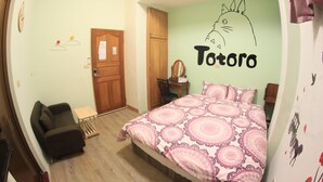 A bedroom with a bed, a small table, a chair, a wooden door, and a wall with a Totoro drawing. - Jiufen Cafe Sleep B&B No.1 Rain House (New Taipei City)