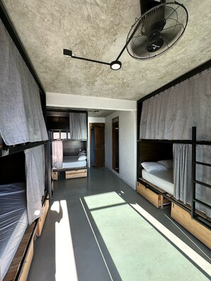 A compact, modern room with bunk beds, a ceiling fan, and a small window allowing natural light. - Straw Hat Surf Hostel (Puerto Escondido)