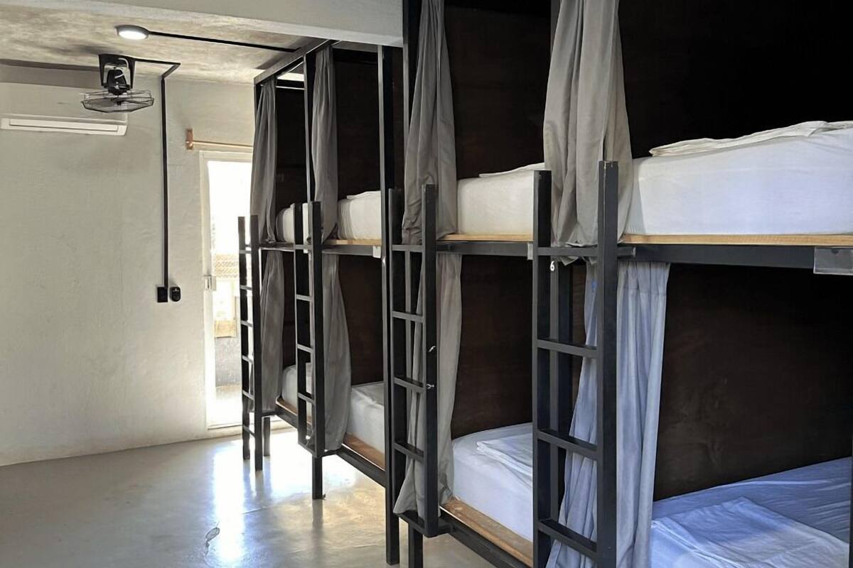Un dormitorio con literas, un ventilador de techo y una ventana.