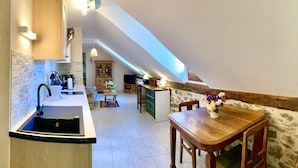 Una cocina moderna con un lavamanos integrado, armarios de madera y un comedor con mesa y sillas de madera.