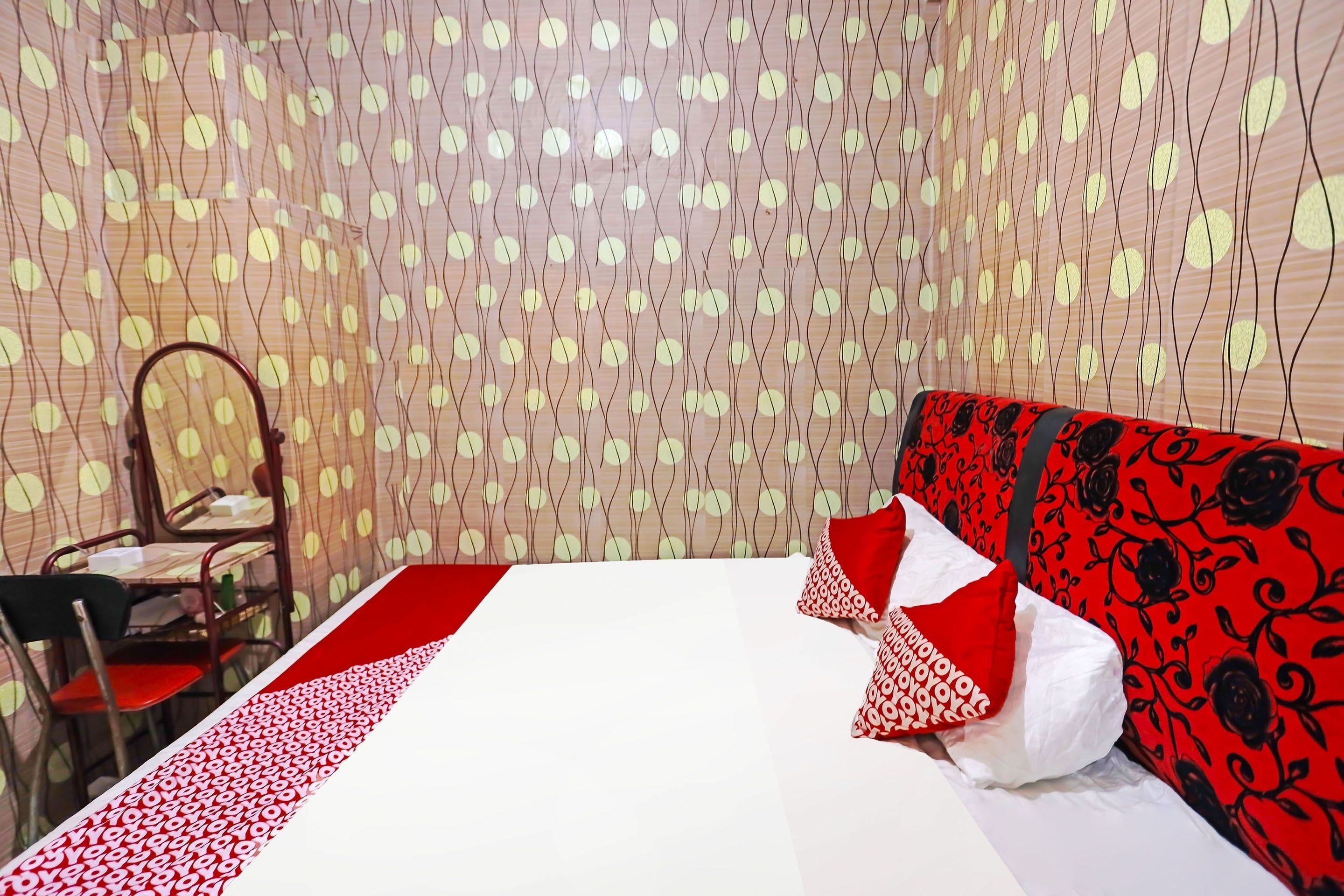 Une chambre d’hôtel avec un lit, une chaise et un rideau à motifs.