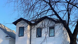 A multi-story building with a staircase leading to a balcony, surrounded by snow. - Rare*Full Home in Downtown Winnipeg|Free Parking (Winnipeg)