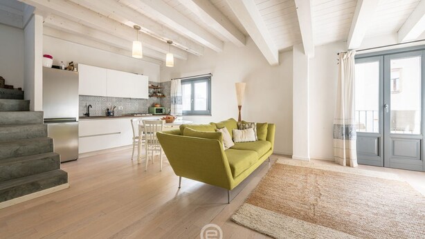 A modern living room with a green sofa, a staircase, and a kitchen in the background. - Tania's House - Wonderful Oristano (Oristano)