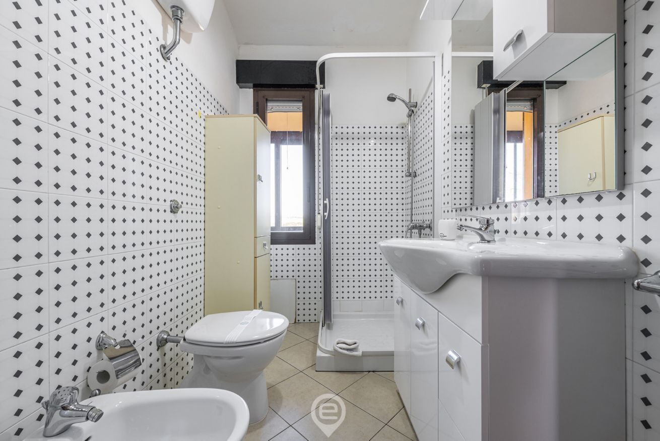 Une salle de bain moderne équipée de toilettes, d’un lavabo et d’une douche.